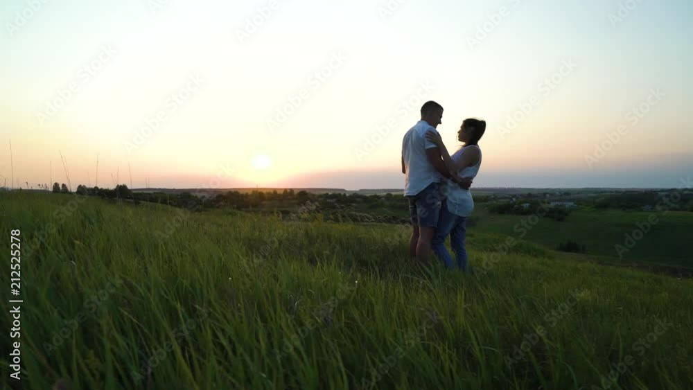Romantic young happy pregnant couple hugging in nature at sunset. Man hugging woman in the evening in fields. Family, marriage, love, devotion, faith concept Romantic young happy pregnant couple hugging in nature at sunset. Man hugging woman in the evening in fields. Family, marriage, love, devotion, faith concept