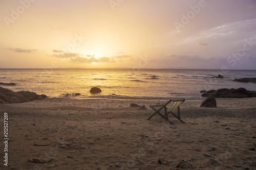 Beach chair on the sand with sunrise sky photo