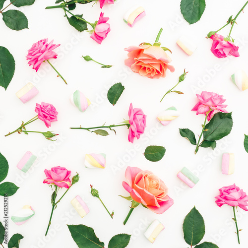 Pattern with roses flowers, leaves and marshmallow candy on white background. Flat lay, top view.