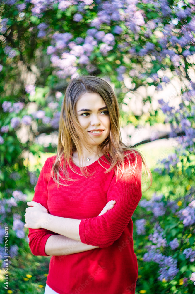 Young beautiful girl in the spring in the park stands in the circle of lilac blossom. Young beautiful girl in the spring in the park stands in the circle of lilac blossom.