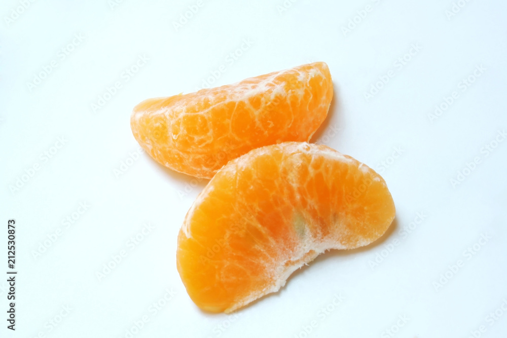 Pieces of mandarin orange fruit on plate background