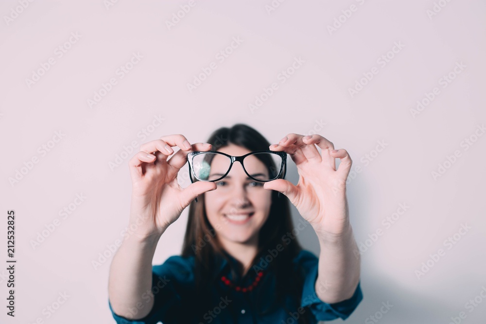 Glasses - optician showing eyewear. Closeup of glasses, with glasses and frame in focus. Woman optometrist on white background.. Glasses - optician showing eyewear. Closeup of glasses, with glasses and frame in focus. Woman optometrist on white background..