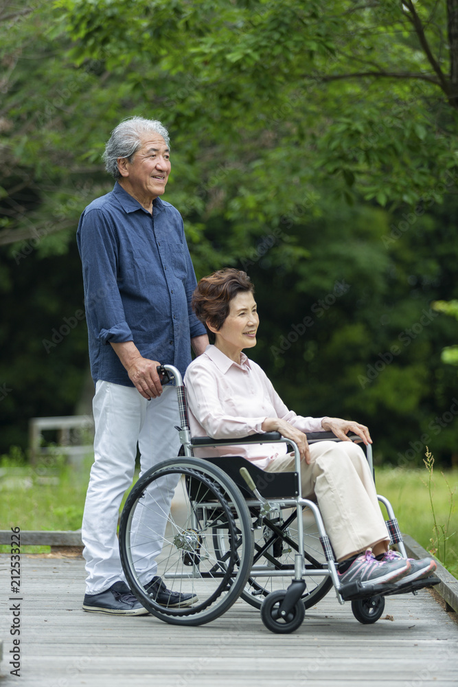 車いすで散歩する老夫婦 車いすで散歩する老夫婦