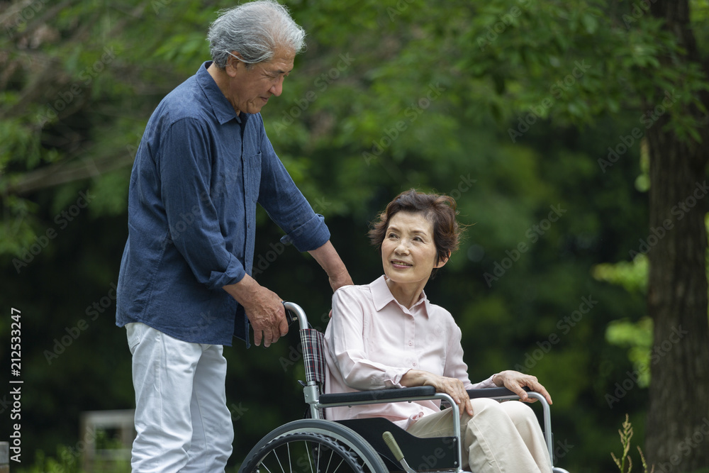 車いすで散歩する老夫婦