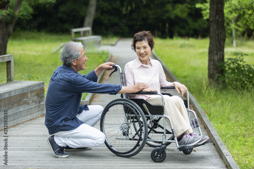 車いすで散歩する老夫婦 車いすで散歩する老夫婦
