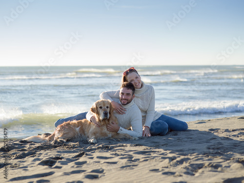 Couple with dog enjoying time on beach