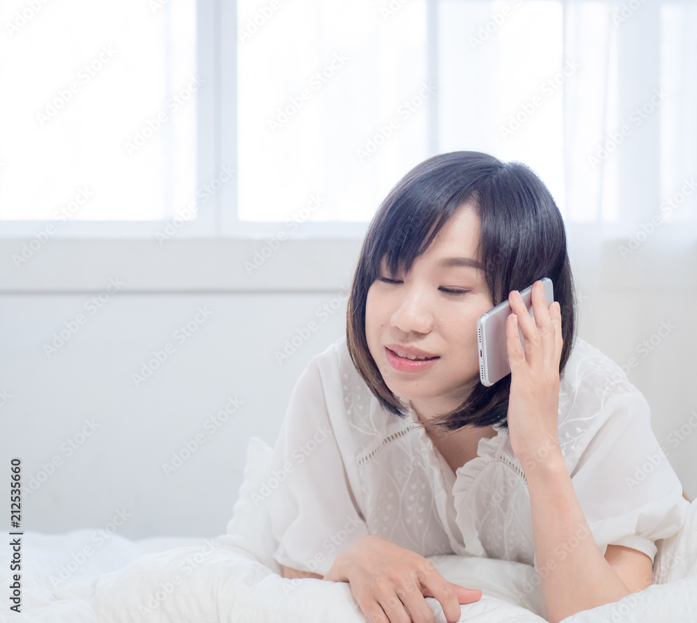 Beautiful young woman talking on the phone while in bed Beautiful young woman talking on the phone while in bed
