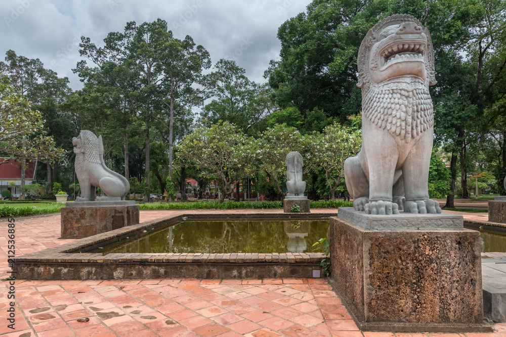 reflections of a lion sculpture angkor in a pond