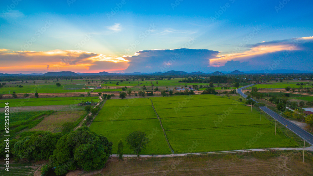 aerial view scenery sunset on new route pass in the rice field. under construction new motorway connect to Myanmar. aerial view scenery sunset on new route pass in the rice field. under construction new motorway connect to Myanmar.