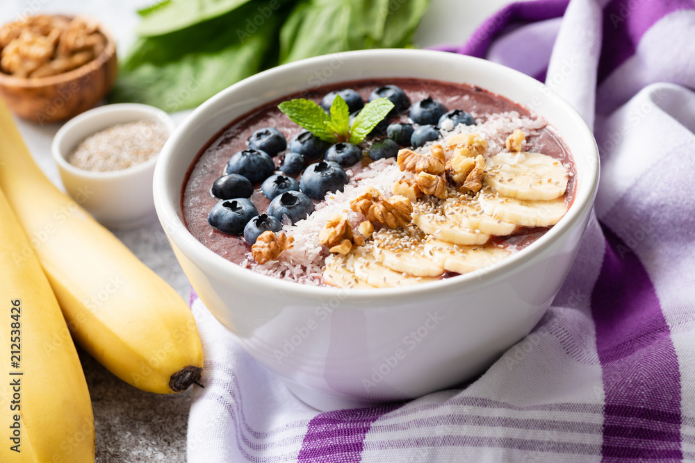 Acai smoothie bowl with superfood toppings - chia seeds, walnut, coconut, blueberries and sliced banana. Detox vegan diet, healthy lifestyle and healthy eating concept Acai smoothie bowl with superfood toppings - chia seeds, walnut, coconut, blueberries and sliced banana. Detox vegan diet, healthy lifestyle and healthy eating concept