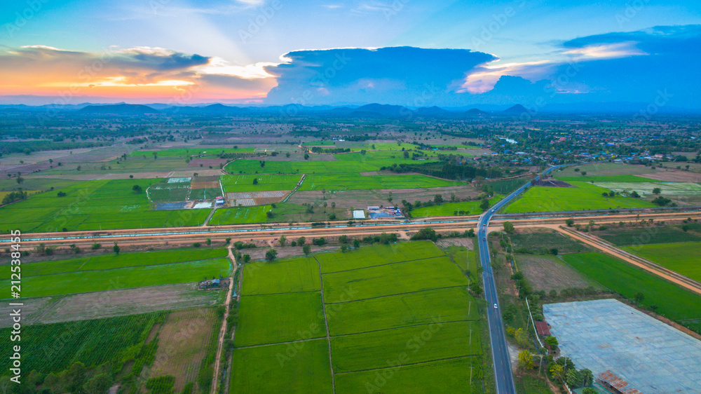 aerial view scenery sunset on new route pass in the rice field. under construction new motorway connect to Myanmar.