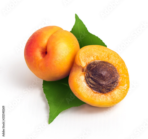 Fresh yellow apricots with green leaf on a white background