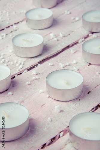 A few flat white candles on a beautiful wooden table