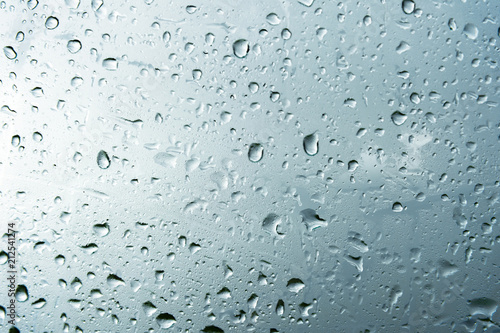 Textured background of window panes with a cloudy background. Natural pattern from a drop of rain on a cloudy background.