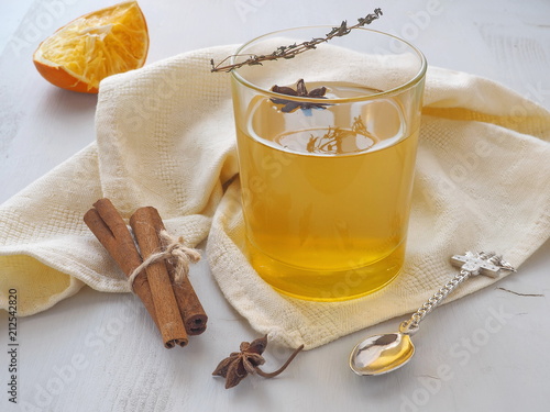 Warming tea with orange, thyme sprig and anise star. Refreshing drink. Selective focus.