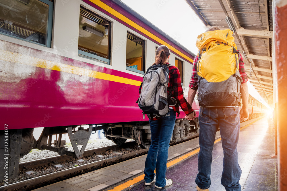 Happy young couple travellers together on vacation at the train station, travel concept, couple concept