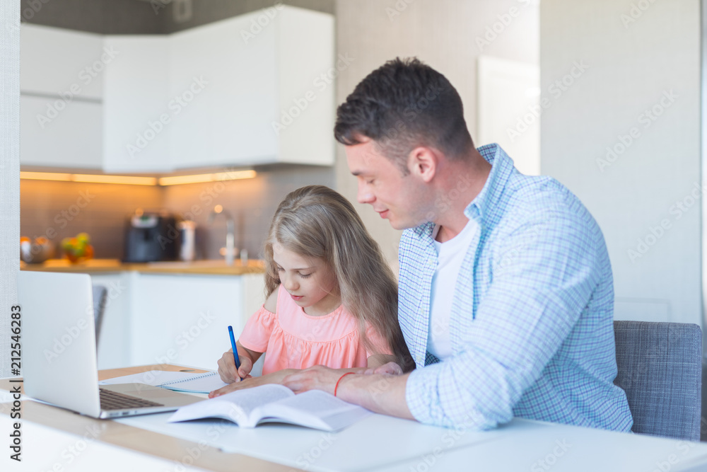 Young father and a little daughter doing homework