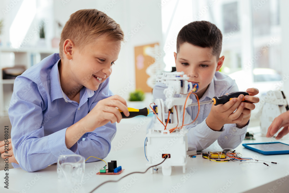 Interesting science. Joyful happy boys having fun while building a robot together Interesting science. Joyful happy boys having fun while building a robot together