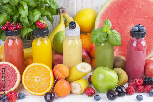 Many different fruits and berries and juices in plastic bottles. Watermelon, banana, applesin, blueberries, strawberries, basil. Vitamin and healthy food. Copy space.