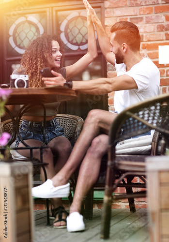 Portrait of a young couple sitting down at a cafe terrace