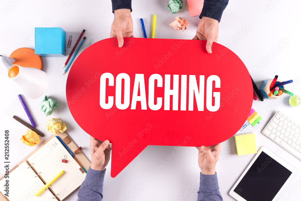 Two people holding speech bubble with COACHING concept Two people holding speech bubble with COACHING concept