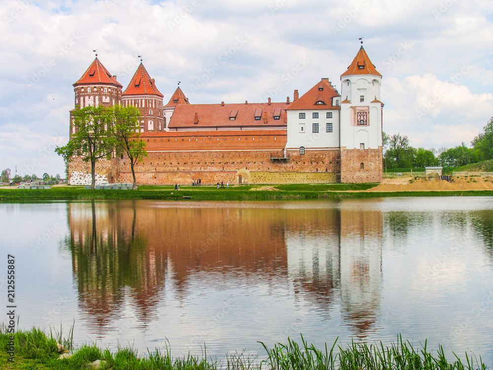 Mir, Belarus. Castle Complex Mir On Sunny Day with blue sky Background. Old medieval Towers and walls of traditional fort from unesco world heritage list Mir, Belarus. Castle Complex Mir On Sunny Day with blue sky Background. Old medieval Towers and walls of traditional fort from unesco world heritage list