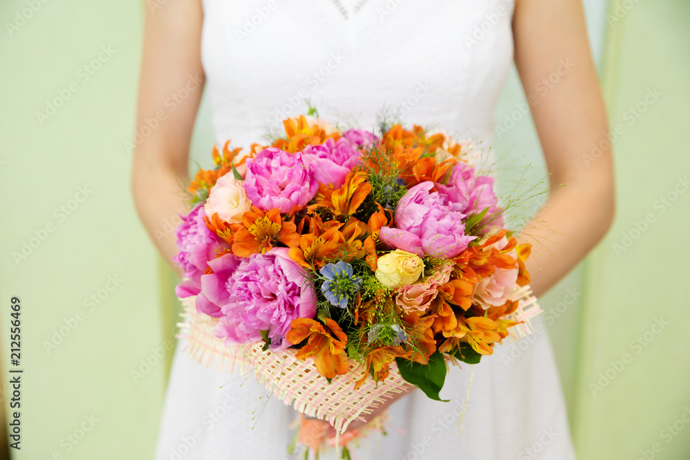 Wedding bouquet of flowers in the hands of the bride