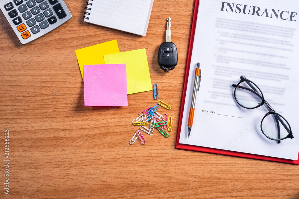 Car insurance working desk concept.Car remote control key,calculator,sticky notes and insurance contract on desk. Car insurance working desk concept.Car remote control key,calculator,sticky notes and insurance contract on desk.
