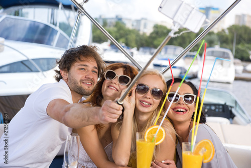 Men and three girls are taking selfie on yacht © Oleksandr