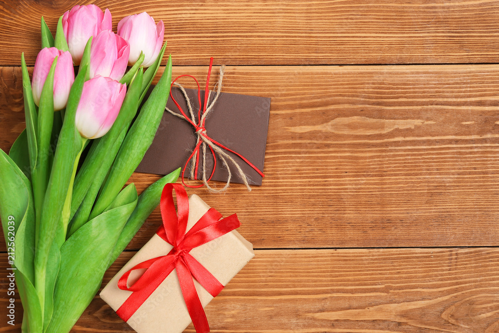 tulips with a gift on a wooden table tulips with a gift on a wooden table