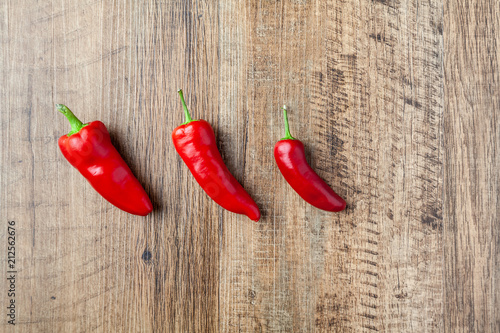 Three red chilli pepper on wooden table