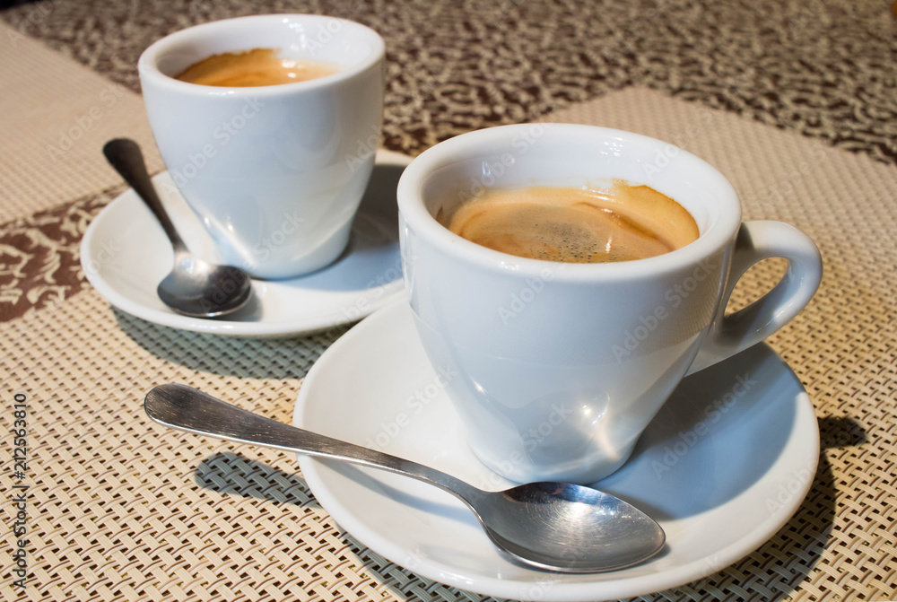 Still-life composition, two coffee cups, white serving plates, small spoons Still-life composition, two coffee cups, white serving plates, small spoons