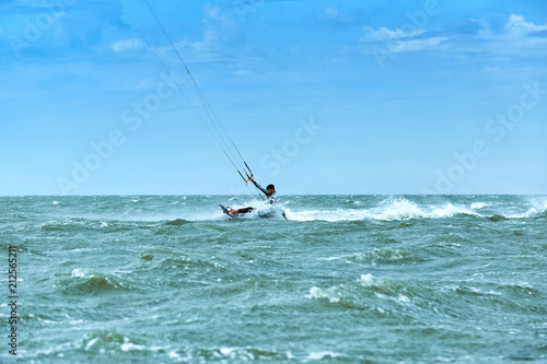 Man riding a kite surfing on the waves in the summer. © trek6500
