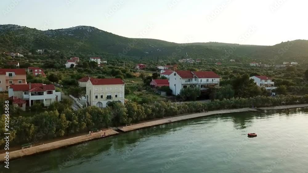 Aerial: Evening flight in front of village Mrljane on island Pasman in Croatia. Shot on vacation in Adriatic sea at Mediterranean coastline. Aerial: Evening flight in front of village Mrljane on island Pasman in Croatia. Shot on vacation in Adriatic sea at Mediterranean coastline.