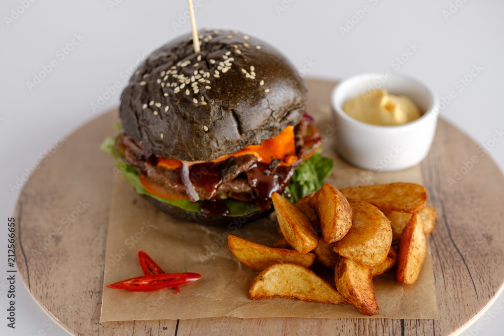 burger with potato wedges on a wooden tray burger with potato wedges on a wooden tray