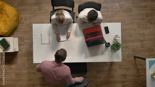 Male candidate for job is interviewed by two employers, topshot, sitting in modern office