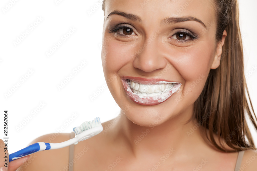 young happy woman brushing her teeth on white background young happy woman brushing her teeth on white background