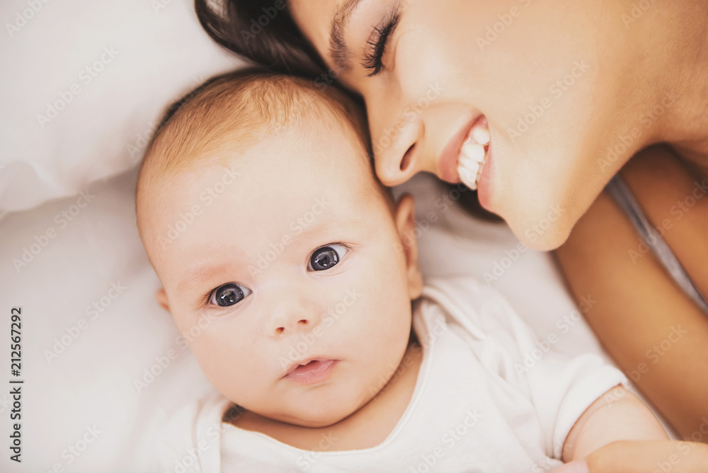 Top view. Happy Young Mother with Baby in Bed. Top view. Happy Young Mother with Baby in Bed.