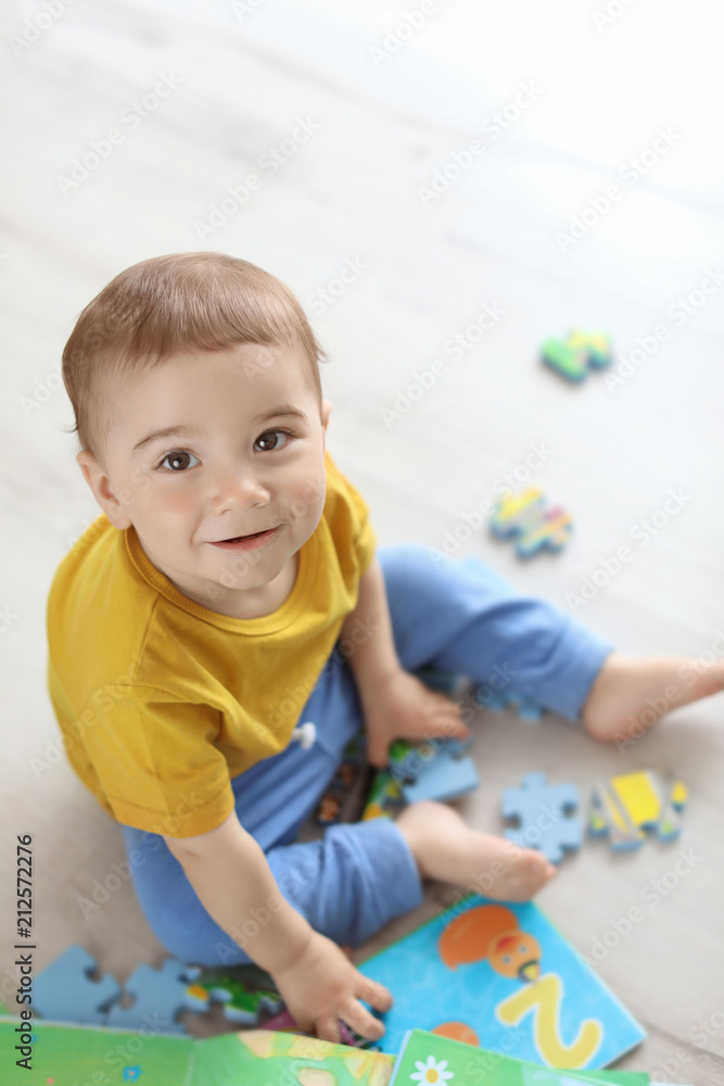 Adorable little boy playing with puzzle indoors Adorable little boy playing with puzzle indoors