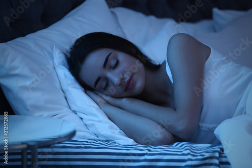 фотографія Young woman sleeping in bed at night. Sleeping time