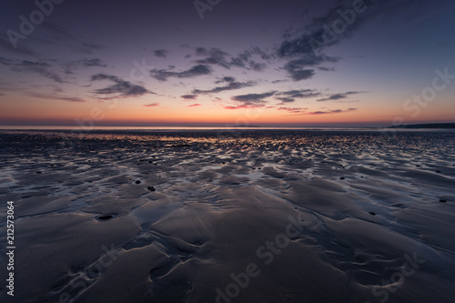 Low tide beach at dusk  colourful sunset light sky