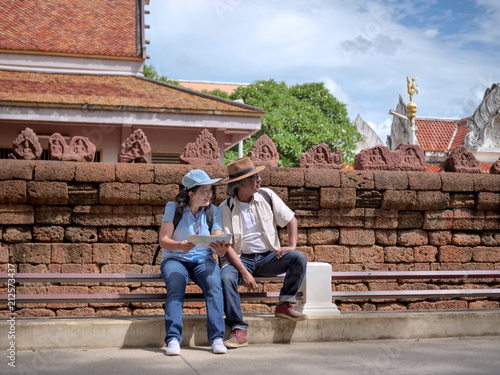 Retired couple walking around the town with a map. summer traveler concept. © chayathon2000