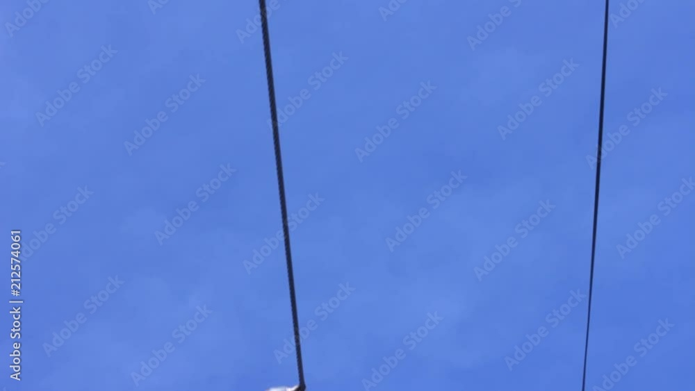 Bottom view of three skiers or six skis going overhead as they ride the chair lift. Bottom view of three skiers or six skis going overhead as they ride the chair lift.