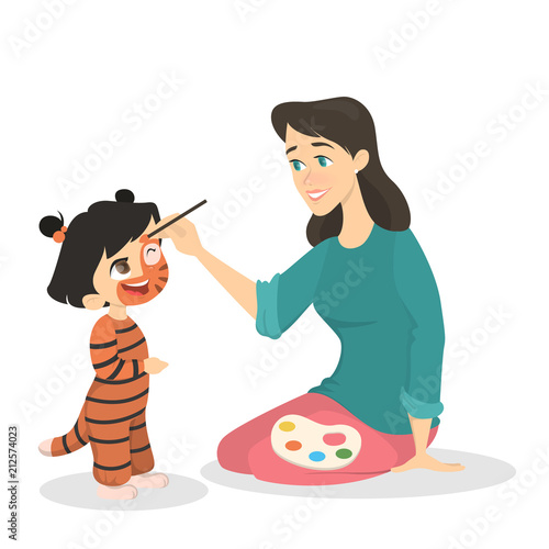 Woman painting the face of the girl in the tiger costume