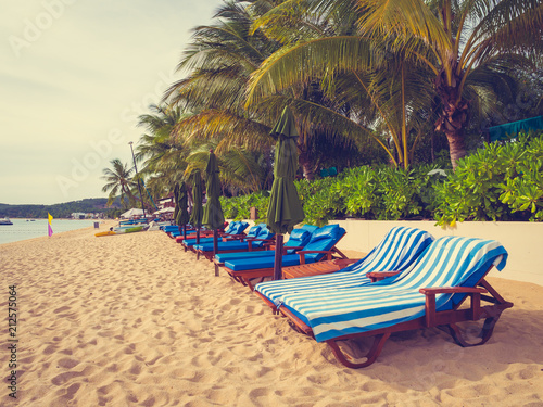 Umbrella and chair on the tropical beach sea and ocean at sunrise time