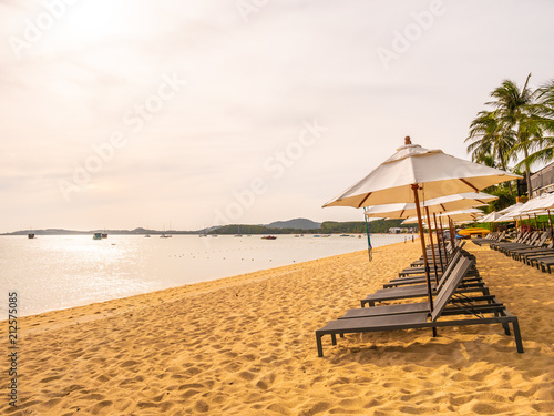 Fototapeta Naklejka Na Ścianę i Meble -  Umbrella and chair on the tropical beach sea and ocean at sunrise time
