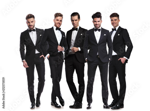 five handsome men in black tuxedoes standing together