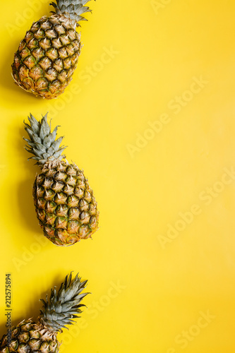 Ripe pineapples border frame on vivid yellow background isolated. Minimalist style trendy tropical concept. Empty space for text, copy, lettering.