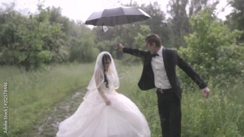 Happy and happy newlyweds with umbrella in the rain. wedding in the rain.