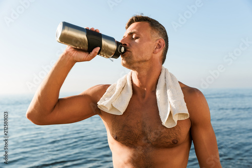 Handsome mature sportsman with towel